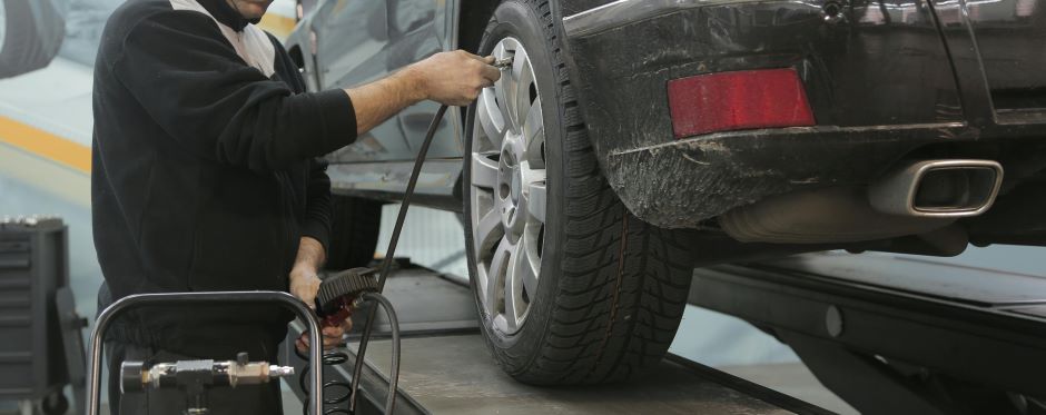 man inflating or checking the pressure of a tire